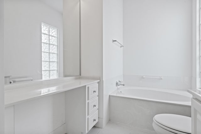 bathroom with tile patterned floors, toilet, a bath, and vanity