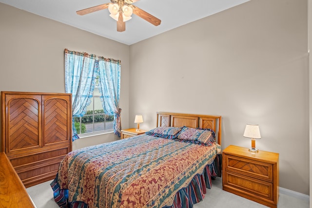 bedroom featuring ceiling fan, multiple windows, and light carpet