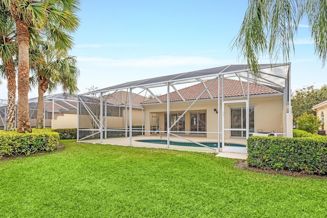 rear view of property featuring a patio area, a lanai, and a yard