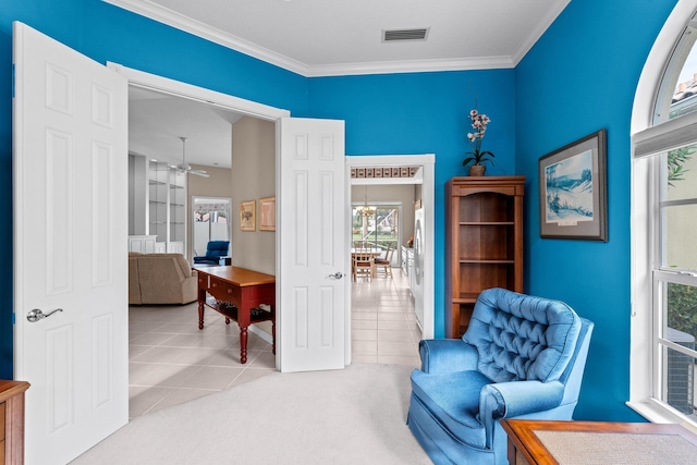 sitting room with ceiling fan, light tile patterned floors, and ornamental molding