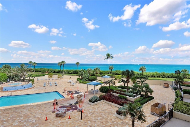 view of pool with a water view and a patio area