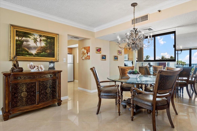 tiled dining area featuring crown molding, a textured ceiling, and an inviting chandelier