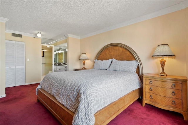 carpeted bedroom with ensuite bathroom, a closet, a textured ceiling, and ornamental molding