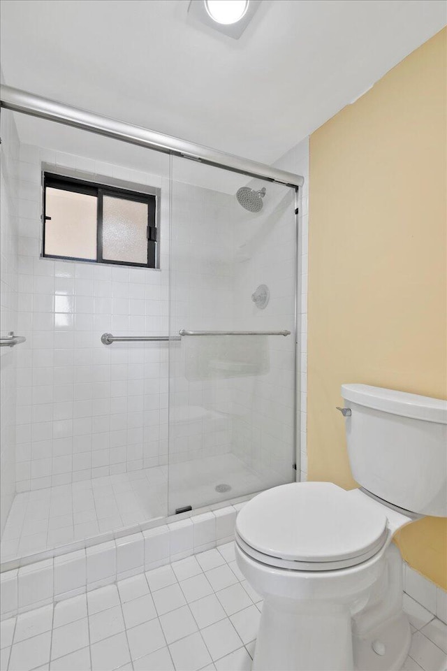 bathroom with toilet, tile patterned floors, and an enclosed shower