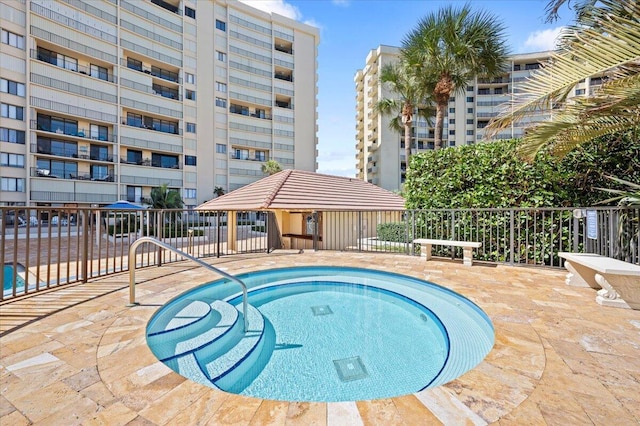 view of swimming pool featuring a hot tub