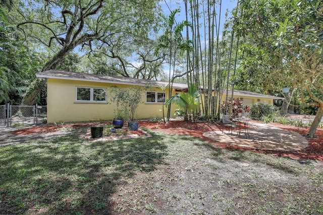 rear view of house featuring a yard and a patio