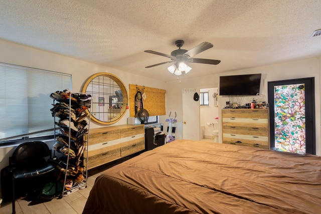 bedroom featuring a ceiling fan, visible vents, connected bathroom, and a textured ceiling