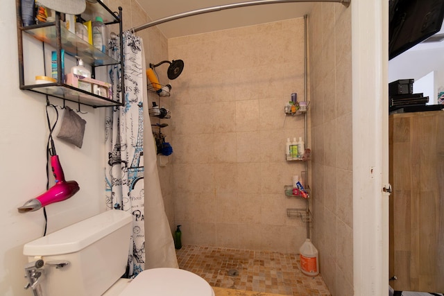 bathroom featuring tiled shower and toilet