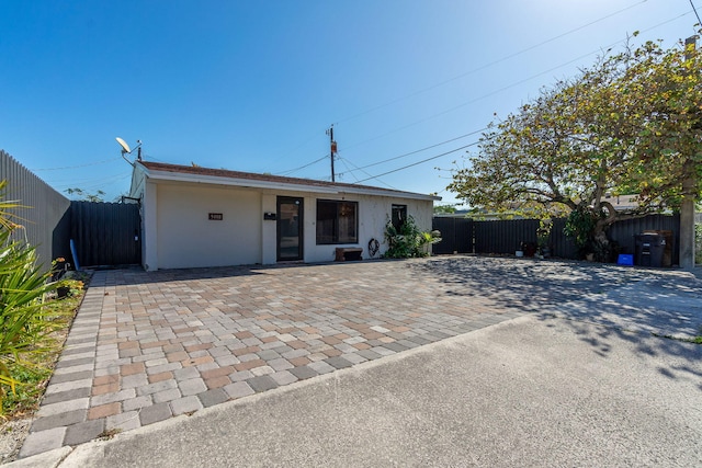 view of front of property with a patio area, a fenced backyard, and stucco siding