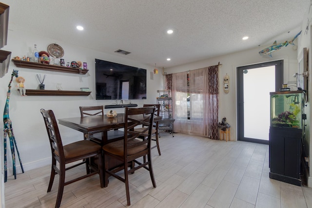 dining space with recessed lighting, visible vents, a textured ceiling, and light wood finished floors