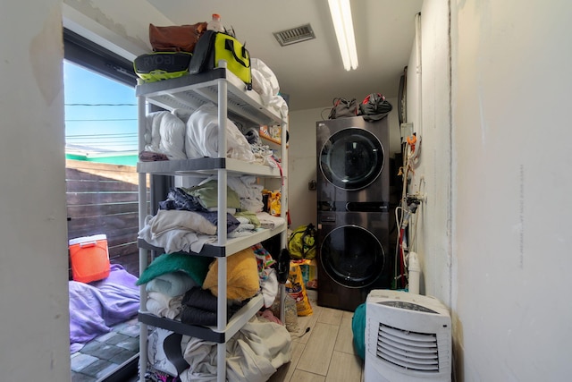 storage with visible vents and stacked washer and clothes dryer