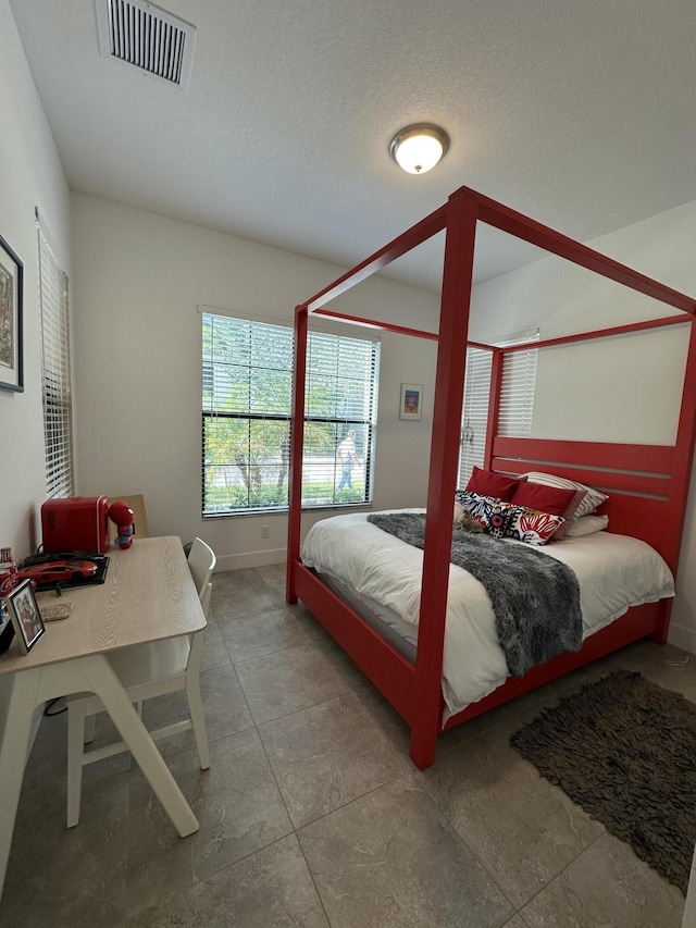 tiled bedroom with a textured ceiling