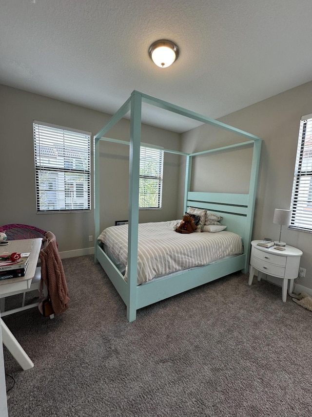 bedroom featuring dark carpet and a textured ceiling