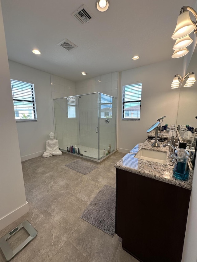 bathroom with an enclosed shower, vanity, and plenty of natural light