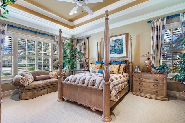 carpeted bedroom featuring a raised ceiling, ceiling fan, and ornamental molding