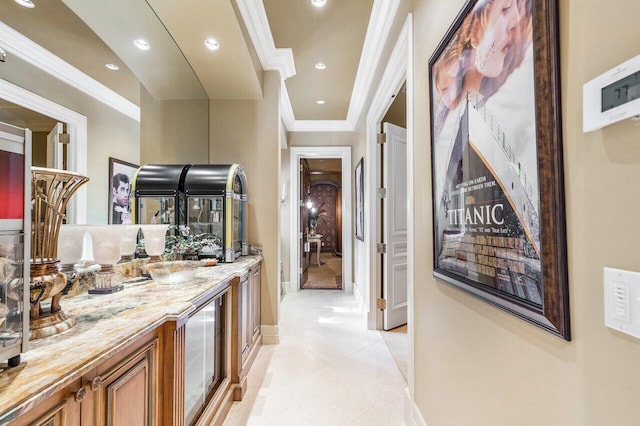 hallway with ornamental molding and light tile patterned floors