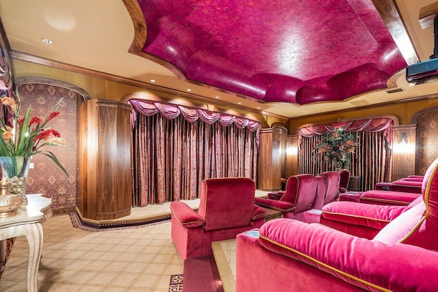 home theater room with a tray ceiling and ornamental molding