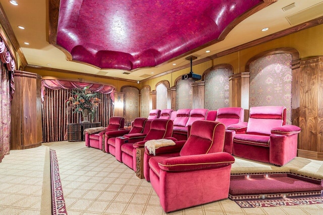 home theater room featuring a tray ceiling and ornamental molding