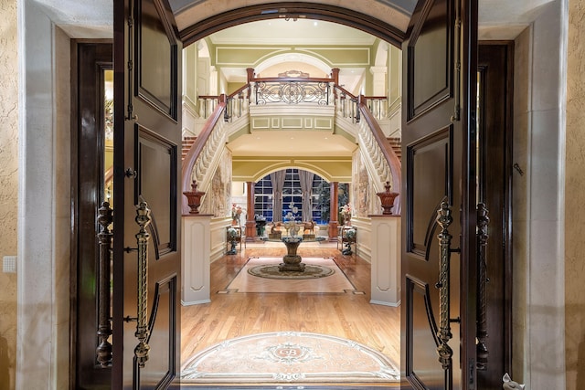 foyer featuring french doors, a high ceiling, crown molding, and wood-type flooring