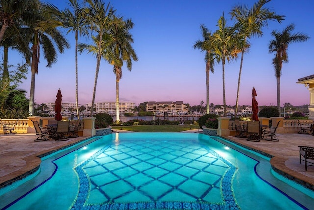 pool at dusk with a patio