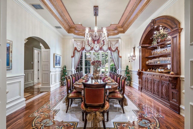 dining space with a tray ceiling and ornamental molding