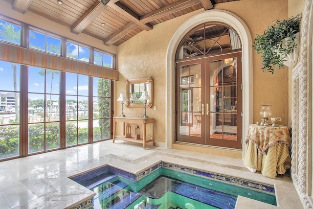 interior space with lofted ceiling with beams, a jacuzzi, and wood ceiling