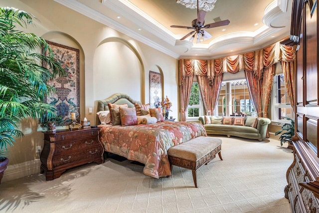 bedroom featuring ceiling fan, a raised ceiling, light colored carpet, and crown molding