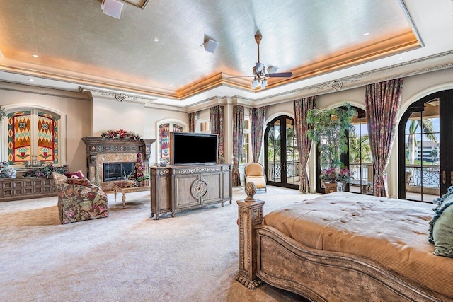 carpeted bedroom with access to exterior, a raised ceiling, ceiling fan, and ornamental molding