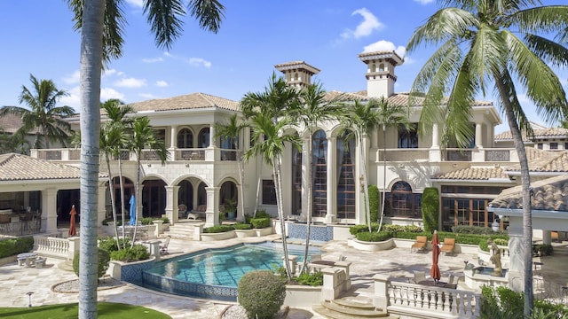 back of property featuring a balcony and a patio