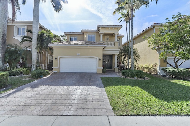 mediterranean / spanish-style home with a front lawn and a garage