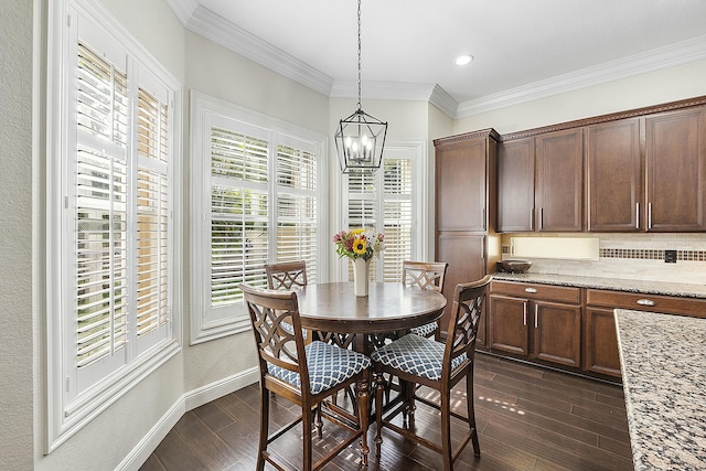 dining area featuring a chandelier, dark wood-type flooring, and crown molding