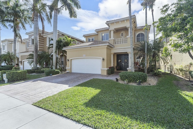 mediterranean / spanish-style house with a balcony, a front yard, and a garage