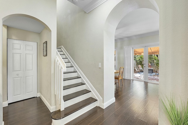 stairs with wood-type flooring, crown molding, and french doors