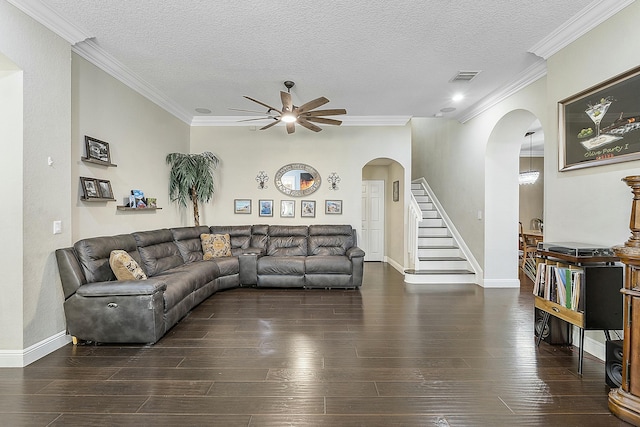 living room with ceiling fan, crown molding, a textured ceiling, and dark wood-type flooring