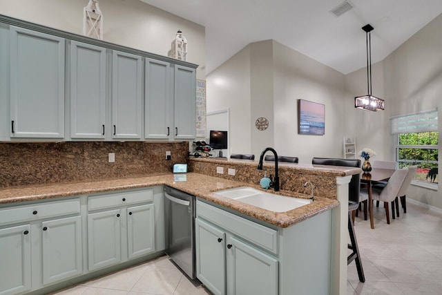 kitchen featuring visible vents, a sink, dishwasher, a peninsula, and a kitchen bar