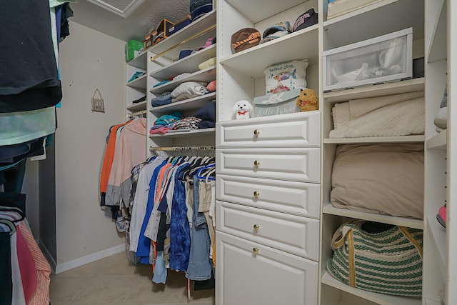 spacious closet with light tile patterned floors