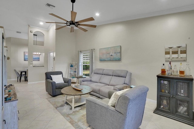 living area featuring crown molding, visible vents, a ceiling fan, light tile patterned flooring, and baseboards