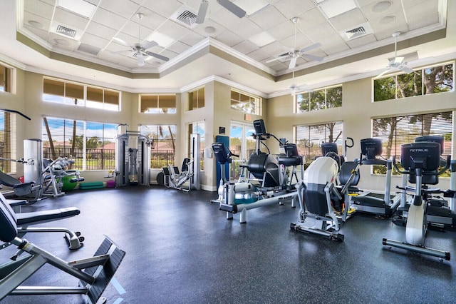 workout area featuring ceiling fan, visible vents, a raised ceiling, and crown molding