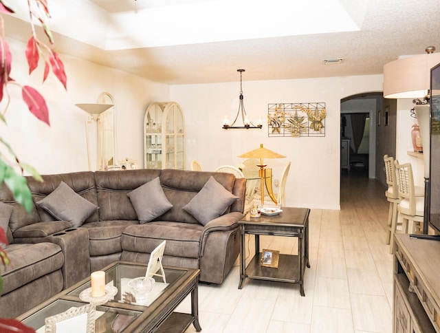 living room with a textured ceiling and a chandelier