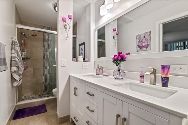 bathroom with tile patterned floors, toilet, vanity, and walk in shower