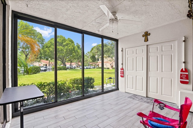 sunroom featuring ceiling fan