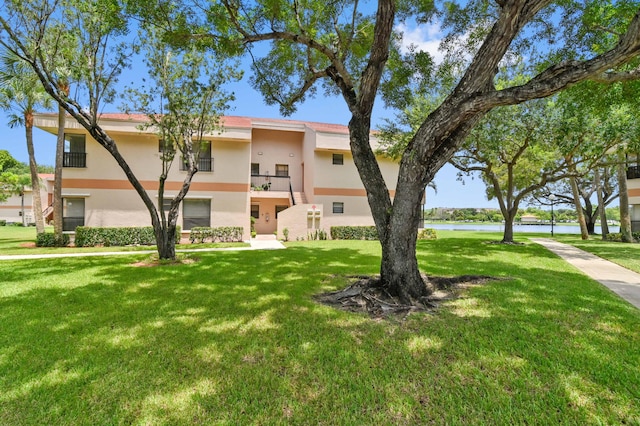 view of front facade with a water view and a front yard