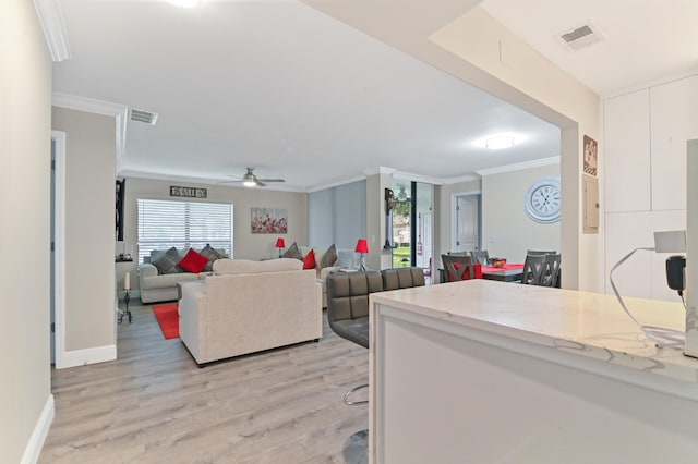 living room with ceiling fan, crown molding, a healthy amount of sunlight, and light wood-type flooring