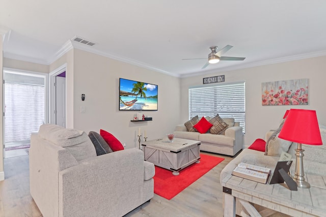 living room featuring ceiling fan, ornamental molding, and light wood-type flooring