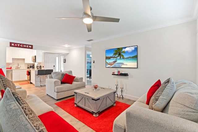 living room with ceiling fan, light wood-type flooring, and crown molding