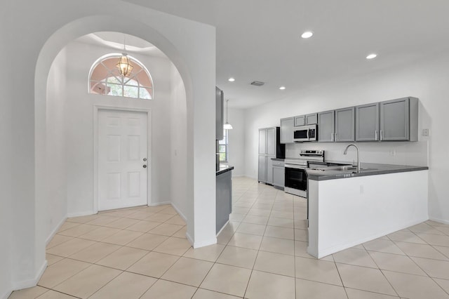 8620 Pine Cay, West Palm Beach, FL 33411 - kitchen featuring white microwave, electric stove, arched walkways, recessed lighting, and light tile patterned floors