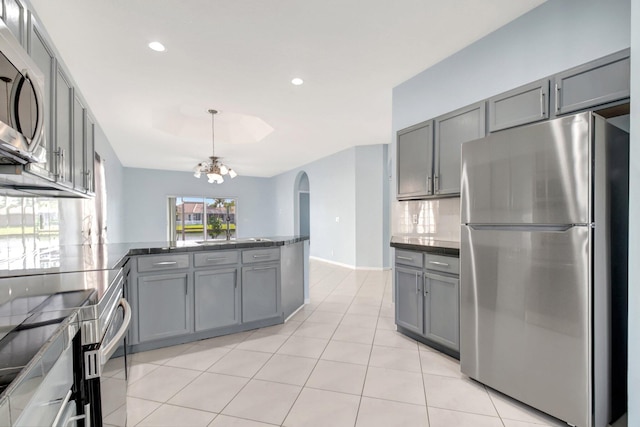 kitchen featuring gray cabinetry, kitchen peninsula, and stainless steel appliances