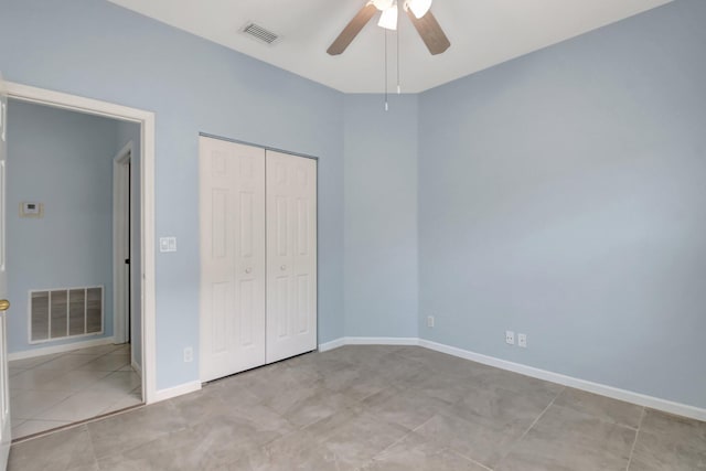 unfurnished bedroom featuring ceiling fan, a closet, and light tile patterned flooring