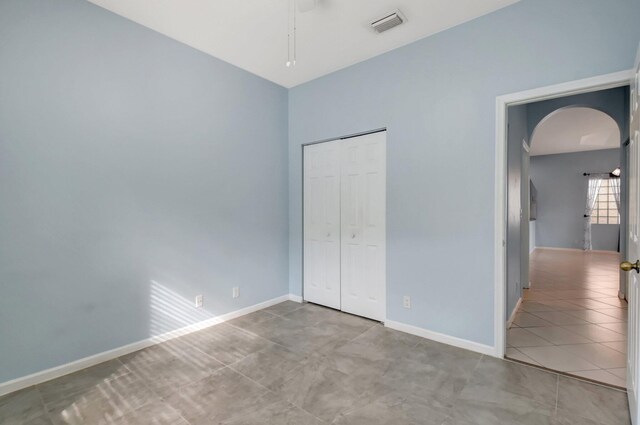 unfurnished bedroom with light tile patterned flooring and a closet