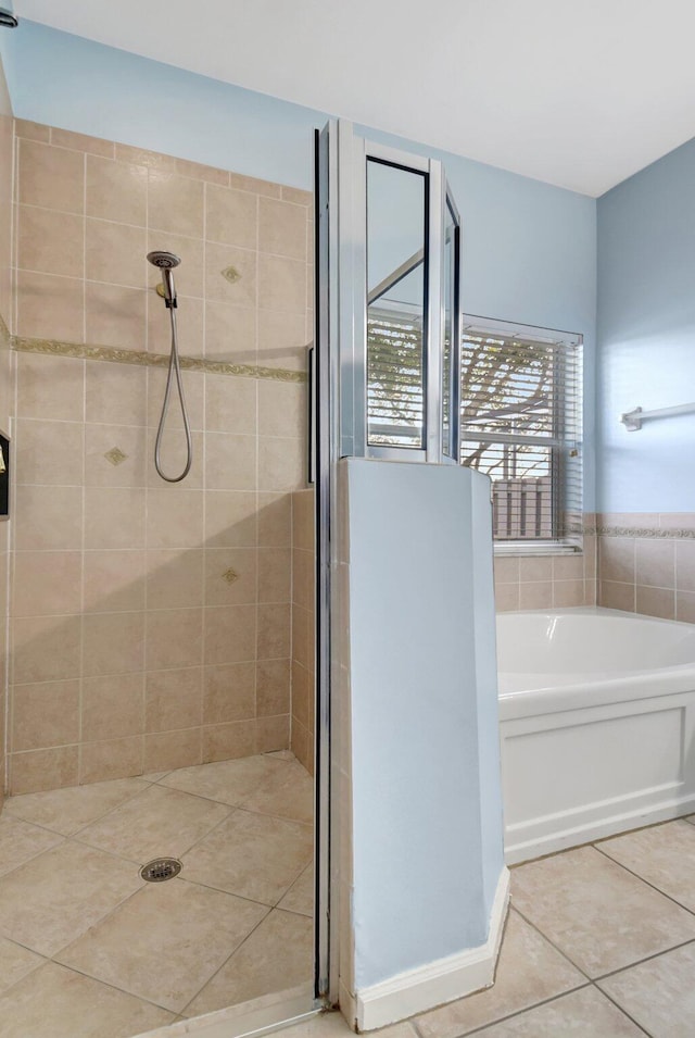 bathroom with tile patterned flooring and shower with separate bathtub